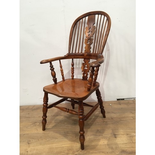 773 - A 19th Century yew and elm Windsor Elbow Chair with pierced splat and stick back, solid seat on turn... 