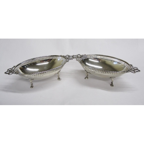 129 - A pair of George V silver oval Dishes with pierced rims and ribbon handles on hoof feet, Birmingham ... 