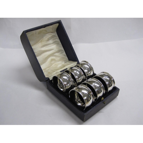 154 - A Set of six George V silver Arts and Crafts circular Napkin Rings, Birmingham 1921, in case.