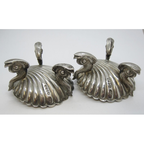 188 - A pair of Victorian silver scallop shape Salts on dolphin supports, London 1875.