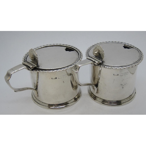 190 - A pair of Edward VII silver drum Mustard Pots with gadroon rims, blue glass liners, Chester 1905.