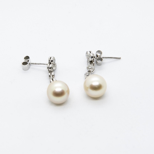 297 - A pair of Diamond and Cultured Pearl Drop Earrings each millegrain-set three brilliant-cut diamonds ... 