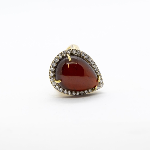 300 - A Garnet and Diamond Cocktail Ring, claw-set large pear-shaped garnet cabochon within frame of pavé-... 