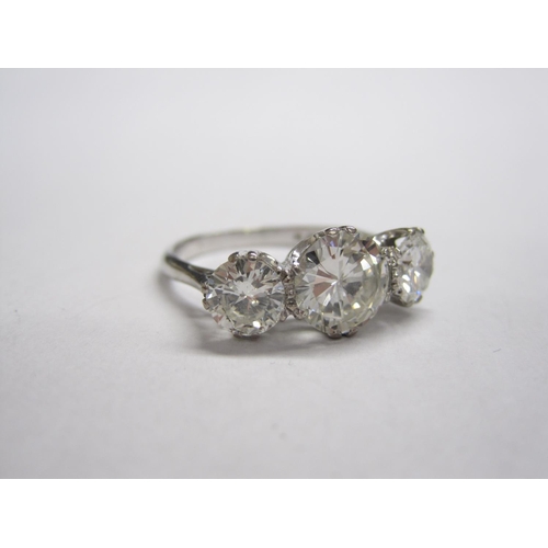 319 - A Diamond three-stone Ring, claw-set graduated brilliant-cut stones, estimated total diamond weight ... 