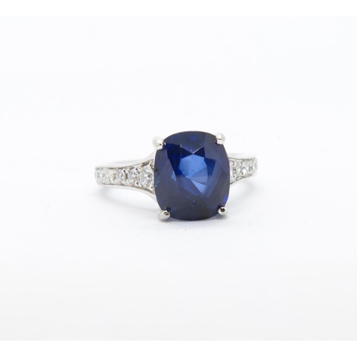 349 - A fine Ceylon Sapphire and Diamond Ring, the cushion-cut sapphire, 6.45cts, between pavé-set graduat... 