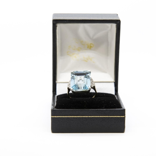 355 - An Art Deco Aquamarine and Diamond Ring, corner claw-set, large step-cut aquamarine between trios of... 