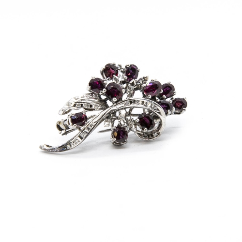 357 - A Ruby and Diamond Flower Spray Brooch, claw-set eleven oval-cut rubies interspersed with illusion-s... 