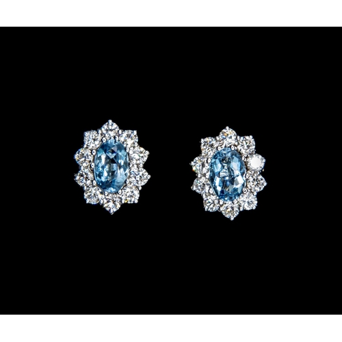 393 - A pair of Aquamarine and Diamond Cluster Earrings, each claw-set oval-cut aquamarine, total weight 1... 