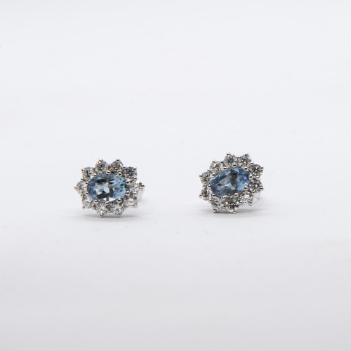 393 - A pair of Aquamarine and Diamond Cluster Earrings, each claw-set oval-cut aquamarine, total weight 1... 