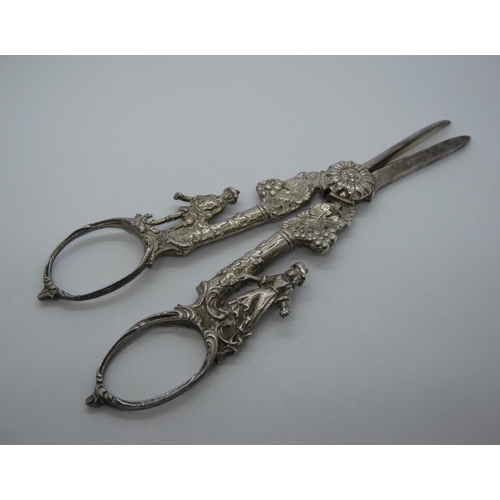 421 - A pair of Continental white metal Grape Scissors with figural handles.