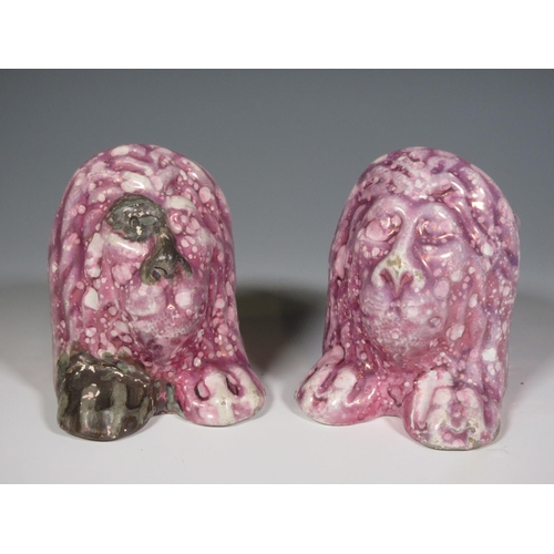 516 - A pair of early 19th Century pink lustre Window Rests in the form of moulded lion heads, one repaire... 