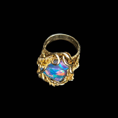 374 - An Opal Doublet Ring, the large oval stone in heavy gold foliate mount, rubbed marks to outside of s... 