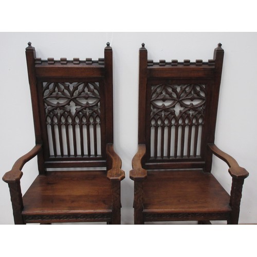 144 - A pair of oak Hall Chairs in the 15th Century Gothic style with tracery pierced backs, solid seats, ... 