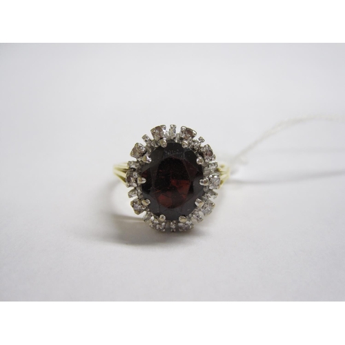 160 - A Garnet and Diamond Cluster Ring claw-set oval-cut garnet within frame of eight-cut diamonds, stamp... 