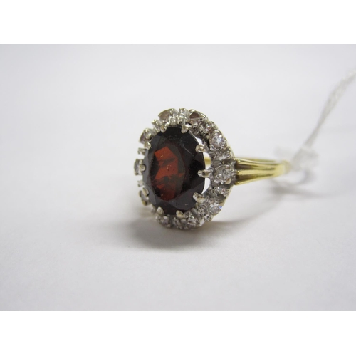 160 - A Garnet and Diamond Cluster Ring claw-set oval-cut garnet within frame of eight-cut diamonds, stamp... 