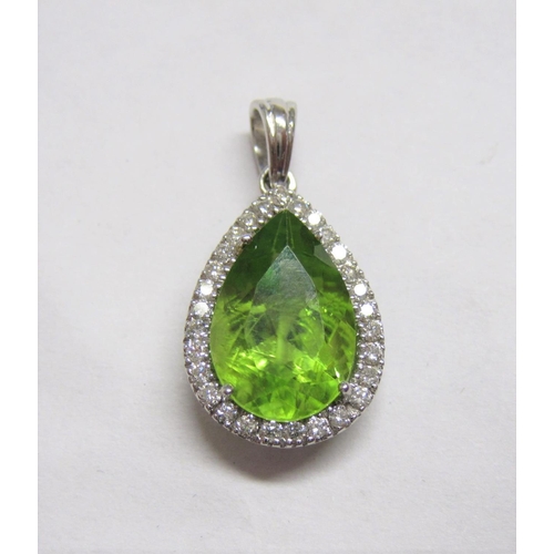 162 - A Peridot and Diamond Pendant, claw-set pear-cut peridot within frame of brilliant-cut diamonds in 1... 