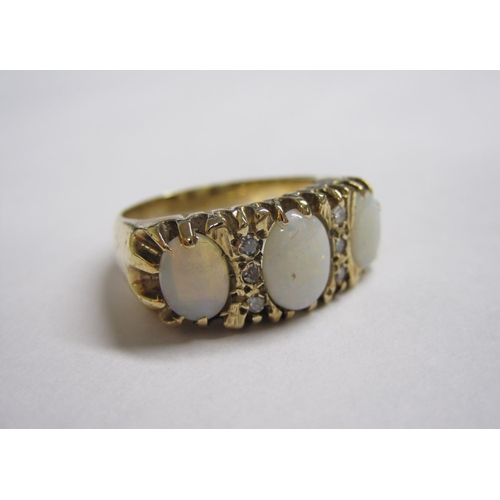 210 - An Opal and Diamond Ring pave-set three graduated oval opals interspersed with trios of eight-cut di... 