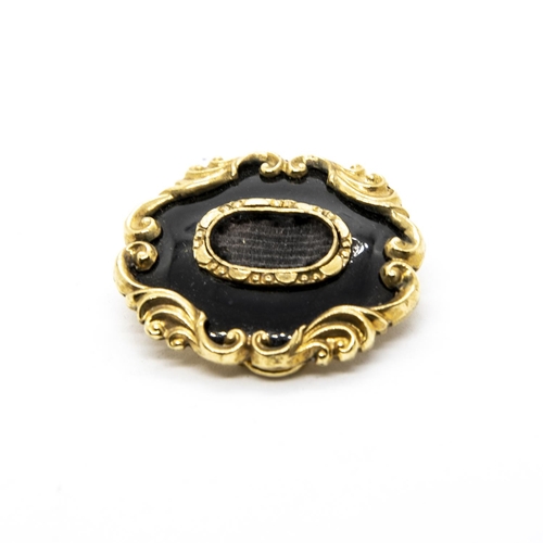 228 - A Victorian Mourning Brooch having lock of woven hair within black enamel and scrolled gold surround... 