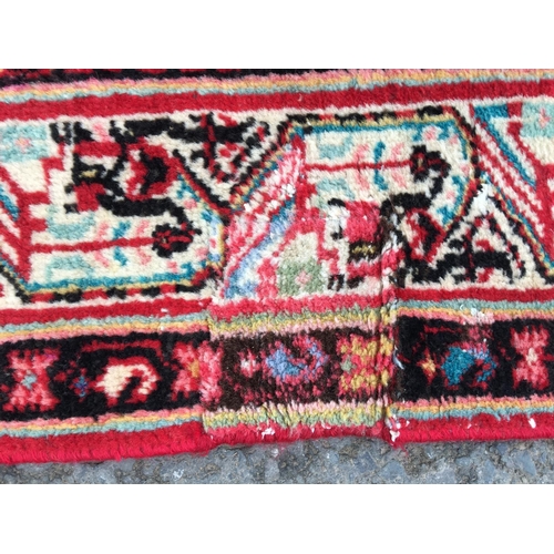 311 - A Persian style Rug, with central lozenge on a red ground 6ft 7in x 4ft 5in, repaired