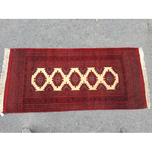 312 - A red Turcoman multi-bordered Rug with central medallions on a cream ground, 6ft 7in x 3ft, and a Ba... 