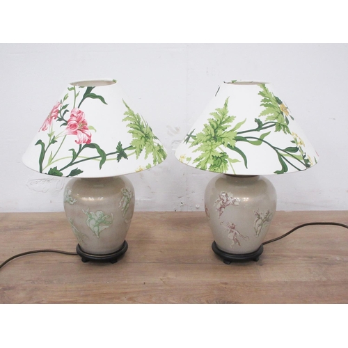 407 - A pair of ceramic Table Lamps and shades decorated with cherubs on ebonised circular bases 1ft 3 1/2... 