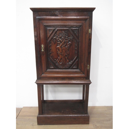 408 - An oak single door Cupboard on stand in the 17th Century style with carved panel depicting Adam and ... 