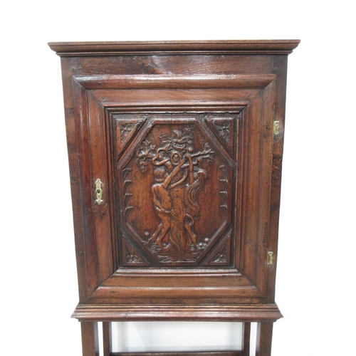 408 - An oak single door Cupboard on stand in the 17th Century style with carved panel depicting Adam and ... 