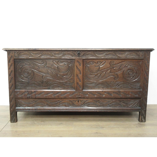 411 - An oak Coffer in the 17th Century style with moulded plank lid above dragon carved two panel front f... 