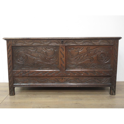 411 - An oak Coffer in the 17th Century style with moulded plank lid above dragon carved two panel front f... 