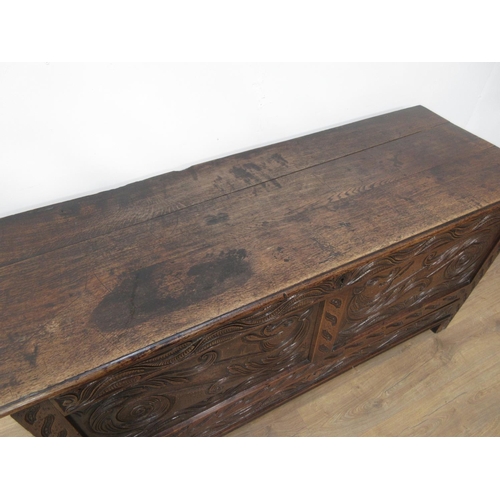 411 - An oak Coffer in the 17th Century style with moulded plank lid above dragon carved two panel front f... 