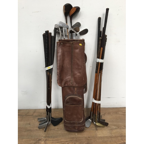 485 - A leather Golf Bag and a quantity of Golf Clubs including those with wooden shafts