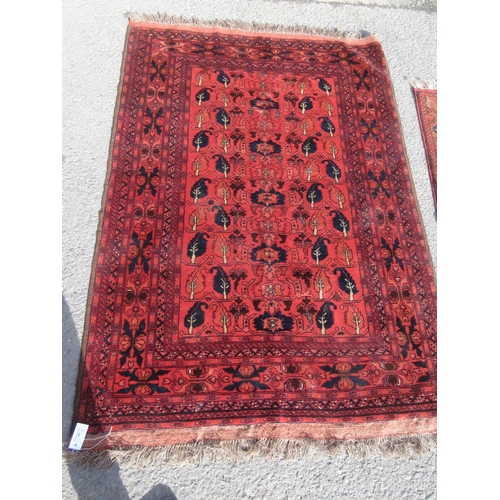 65 - A red ground Rug with blue stylised leafage design 6ft 6in L x 4ft 4in W and another smaller red gro... 