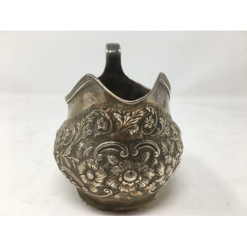 250 - A George III silver Milk Jug with floral embossing and reeded rim, London 1804, 152 gms.