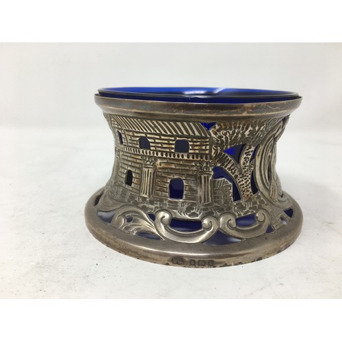 255 - An Edward VII silver Dish Holder embossed shepherd and sheep, Birmingham 1909, blue glass liner.