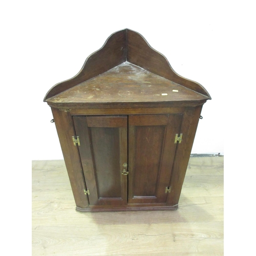 130 - An antique oak Hanging Corner Cupboard with raised back and pair of doors enclosing shaped shelves, ... 