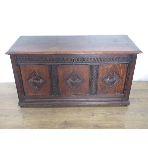 381 - An antique oak Coffer with hinged top and carved three panel front, 4ft 7in W