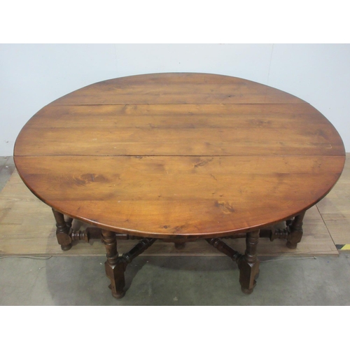 504 - A large walnut dropleaf gateleg Dining Table on turned supports and stretchers 5ft 11 in open x 6ft ... 