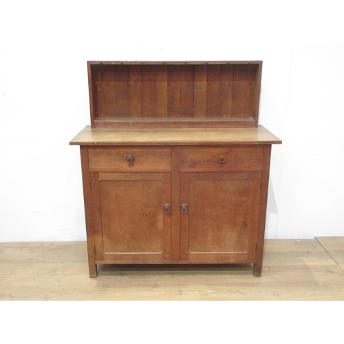 525 - A Heal & Son Ltd, London oak Cupboard with raised back mounted with turned pegs (one missing) and fi... 