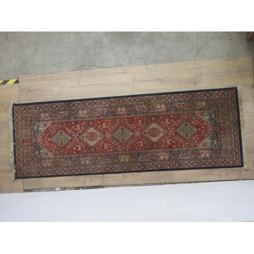 564 - A Persian style Runner with design of central lozenges on a red ground 8ft x 2ft 8in.