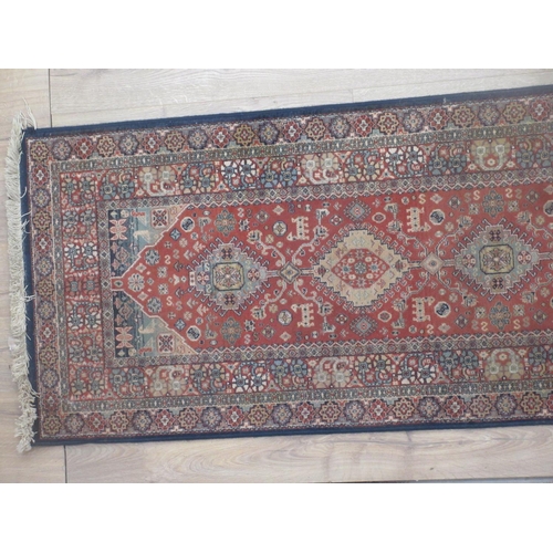 564 - A Persian style Runner with design of central lozenges on a red ground 8ft x 2ft 8in.