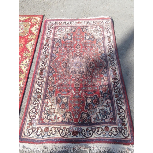 67 - A red ground woollen Rug with stylised floral design within cream border 5ft 4in L x 3ft 2in W and a... 