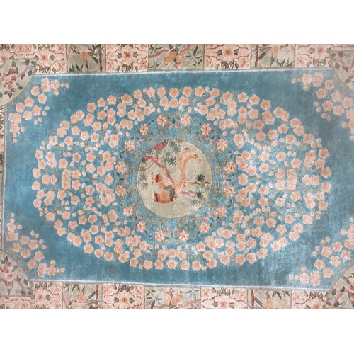 563 - A small bordered Rug with central panel of birds on a branch on a blue ground 6ft 2in x 4ft.