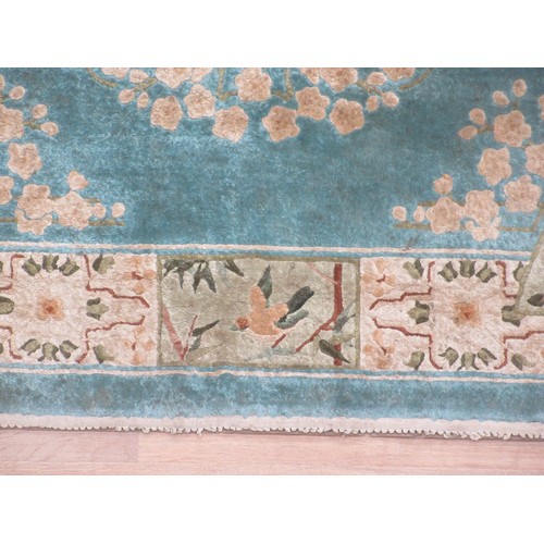 563 - A small bordered Rug with central panel of birds on a branch on a blue ground 6ft 2in x 4ft.