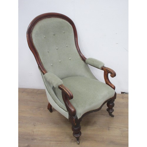 569 - A Victorian button upholstered Armchair on turned front supports and casters.