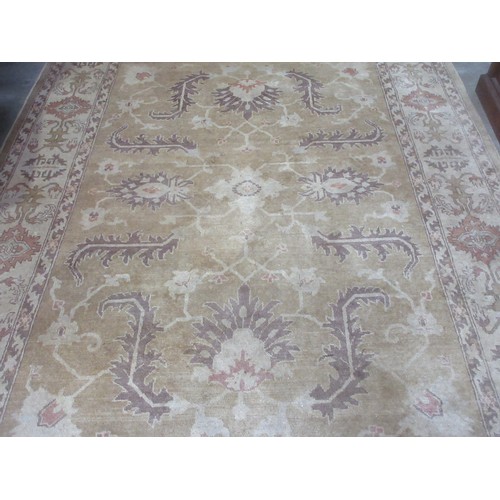 605 - A bordered Persian rug with floral motifs on a beige ground, 9ft 8in x 7ft 1in.