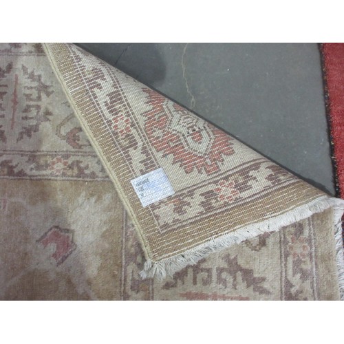 605 - A bordered Persian rug with floral motifs on a beige ground, 9ft 8in x 7ft 1in.