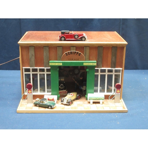 168 - A wooden scratch built model of 'Scripps Garage' with vehicles, figures and equipment 1ft 5in W x 10... 