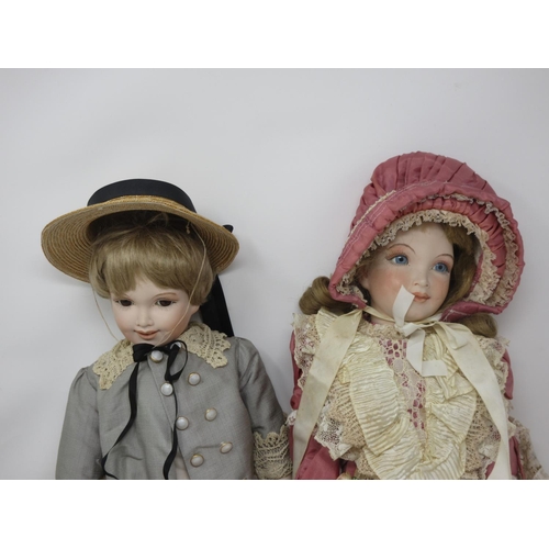 202 - A bisque headed Girl Doll in pink lace Victorian style dress, stamped Paul 1985 and a Boy Doll in bl... 