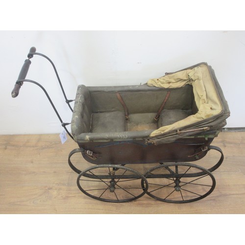 210 - An Edwardian Doll's Pram in black with iron wheel, drop handle in wood and iron, opening hood and bu... 