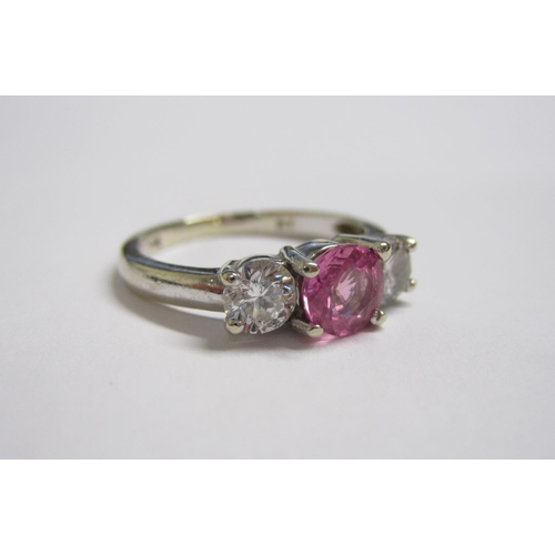 156 - A Pink Sapphire and Diamond three stone Ring claw-set round sapphire between two brilliant-cut diamo... 